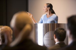 Businesswoman giving presentation at podium